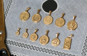 Detailansicht vergoldeter Edelstahl-Anhänger mit römischen Münzen und Reliefmotiven
