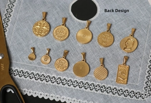 Detail der vintage 18K vergoldeten Titanstahl-Münzanhänger mit Reliefprägungen