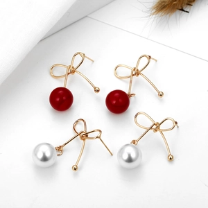 Detailansicht der Kirsch-Ohrstecker mit roten Perlen und goldenem Schleifen-Design
