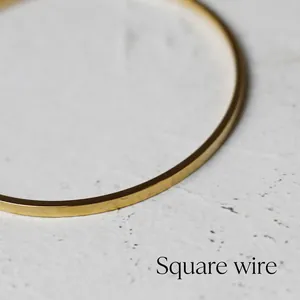 Detailed close-up showing the square wire design and golden finish of the thin bracelet