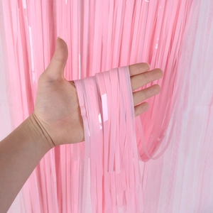 Close-up of pink tinsel fringe curtain texture with shiny metallic foil material