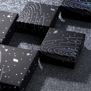 Close-up of black square jewelry gift boxes with silver starry sky and galaxy patterns