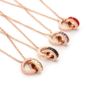 Detail of rose gold stainless steel necklaces with roman numerals and colorful zircons