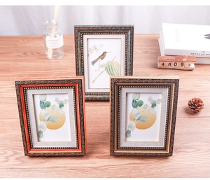 Detail of luxury vintage embossed photo frames with ornate relief patterns on wooden table