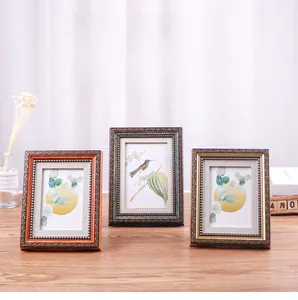 Close-up of vintage picture frames with beaded texture and hummingbird botanical art