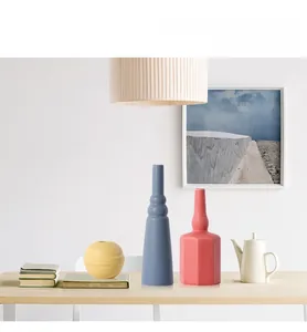 Κοντινό πλάνο με ματ κεραμικά βάζα Morandi σε μπλε στρογγυλά και ροζ γεωμετρικά σχήματα