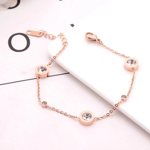 Detail of rose gold titanium steel bracelet featuring three circular zircon pendants