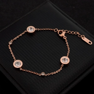 Elegant rose gold stainless steel bracelet with five round sparkling crystals on a black box