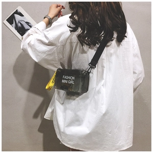 Close-up of gray translucent PVC mini crossbody bag with yellow branded strap and fashion logo