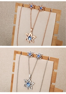 Detailed view of floral jewelry sets with blue gemstones in rose gold and silver finishes
