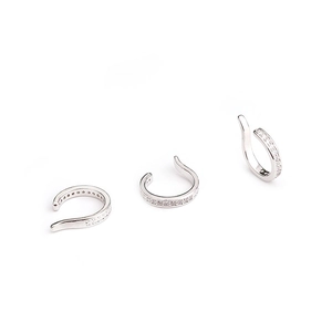 Gros plan de trois boucles d'oreilles clips en argent sertis de zircons cubiques