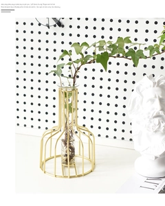 Gros plan d'un vase tube en verre avec cadre en fer doré pour décoration hydroponique
