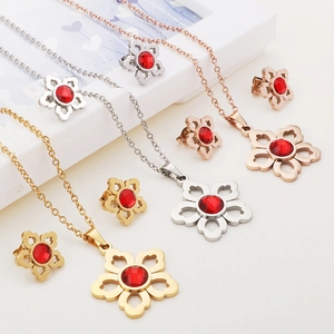 Three sets of flower jewelry sets in gold, silver, and rose gold with red crystals