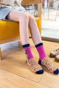 Close-up of women's leopard print crew socks in vibrant orange, pink and blue tones
