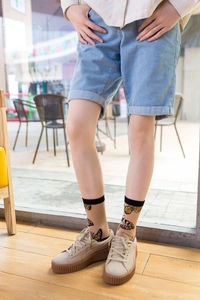 Close-up of khaki cotton socks with butterfly pattern worn with trendy sneakers