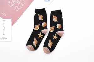 Detail of black cotton socks with golden seashell pattern and light brown heel and toe