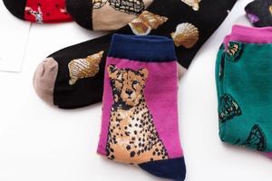 Detailed view of colorful crew socks with leopard and seashell patterns in soft combed cotton