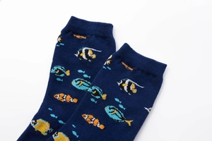 Detail of dark blue cotton socks featuring colorful tropical fish patterns and soft texture
