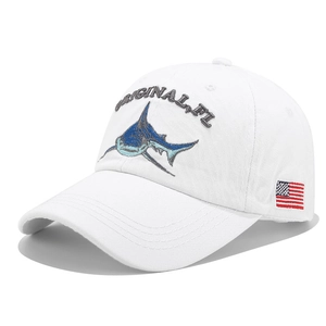 Detail view of shark embroidery and American flag patch on white cotton baseball cap