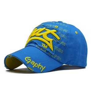 Detail of blue baseball cap featuring yellow 3D embroidery and distressed ripped effects