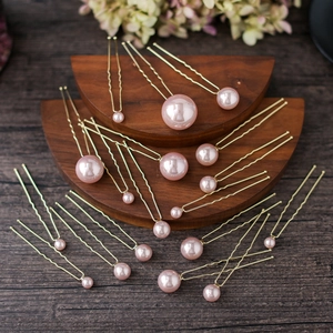 Pink pearl U-shaped hair pins set displayed on elegant wooden stand for bridal styling
