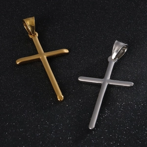 Polished stainless steel cross pendants in gold and silver finish on a dark background