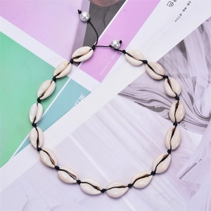 Detailed macro view of natural white seashells and pearls on a bohemian choker necklace