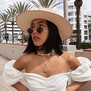 Detail of a natural shell choker and gold pendant necklace on a fashion model in a summer setting