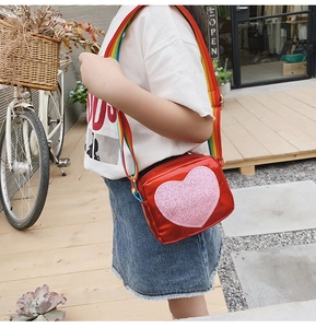 Détail du sac à bandoulière en cuir PU coeur rouge pour filles avec sangle arc-en-ciel colorée