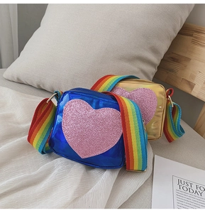 Détail de sacs pour filles bleus et dorés avec bandoulière arc-en-ciel et cœur