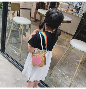 Fille portant un sac à bandoulière doré en forme de cœur avec sequins roses et sangle arc-en-ciel