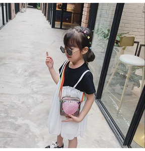 Détail du sac bandoulière argenté irisé pour enfant avec cœur rose et sangle arc-en-ciel