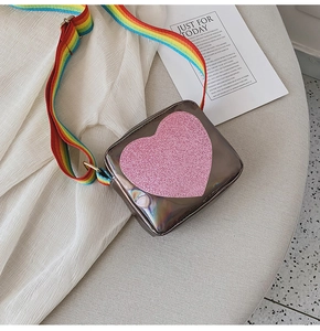 Détail du mini sac argenté irisé avec cœur pailleté et bandoulière arc-en-ciel