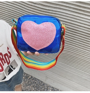 Détail du sac bandoulière coeur bleu pour filles avec finition pailletée et sangle arc-en-ciel