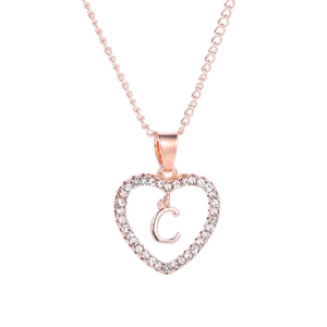 Gros plan du pendentif cœur en or rose avec lettre C et cristaux sur une chaîne fine
