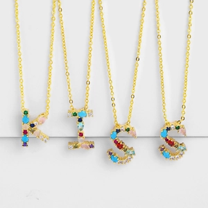 Detail of gold initial necklaces with multi-colored crystals spelling KISS on chains