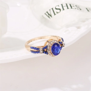 Detailed close-up of an oval blue zircon ring with gold plating and diamond accents