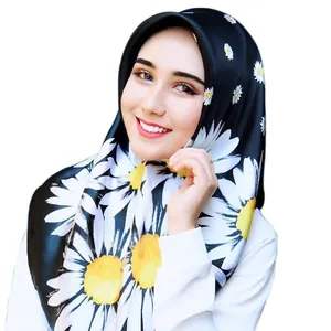 Detailed view of women's black satin hijab featuring large white and yellow daisy prints