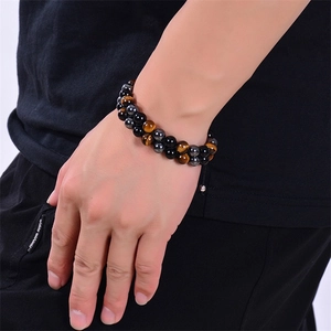 Macro detail of double-layered tiger eye and hematite stone beads on men's bracelet