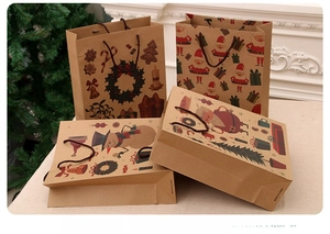 Detail of four Christmas kraft paper gift bags featuring festive patterns and rope handles