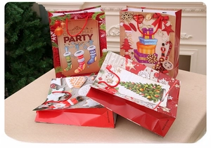 Detail of Christmas paper gift bags with festive Nutcracker and tree patterns and red handles