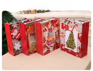 Four festive Christmas gift bags with sturdy red handles and holiday paper bag graphics
