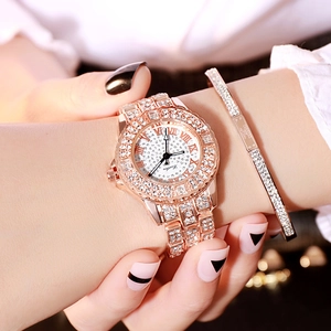 Close-up of a luxury gold quartz watch and matching crystal bracelet on a wrist