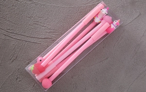 Detailed view of pink cartoon pens with 3D unicorn toppers in a transparent box