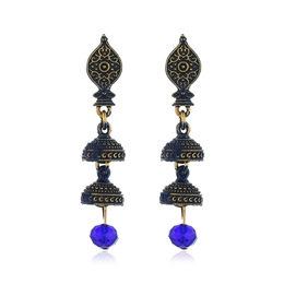 Detailed close-up of ethnic gold geometric earrings with pavé rhinestones and blue beads