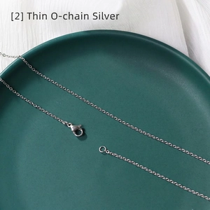 Macro view of a thin silver O-chain necklace featuring a classic lobster clasp closure