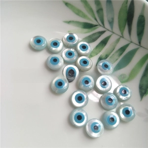 Detailed view of flat round evil eye shell beads with natural mother of pearl luster