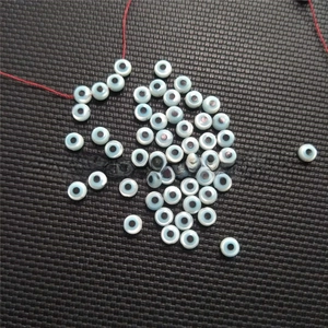 Macro detail of round light blue shell evil eye beads for DIY jewelry making and crafts