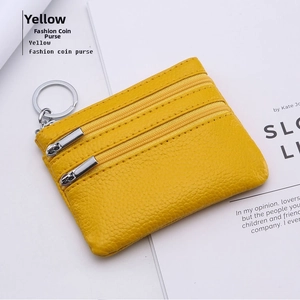 Close-up of yellow pebble leather wallet showing three zipper layers and key ring