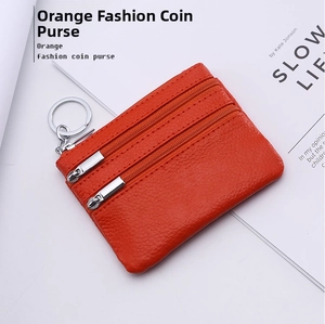 Close-up of orange litchi grain leather coin purse with three zippers and key ring